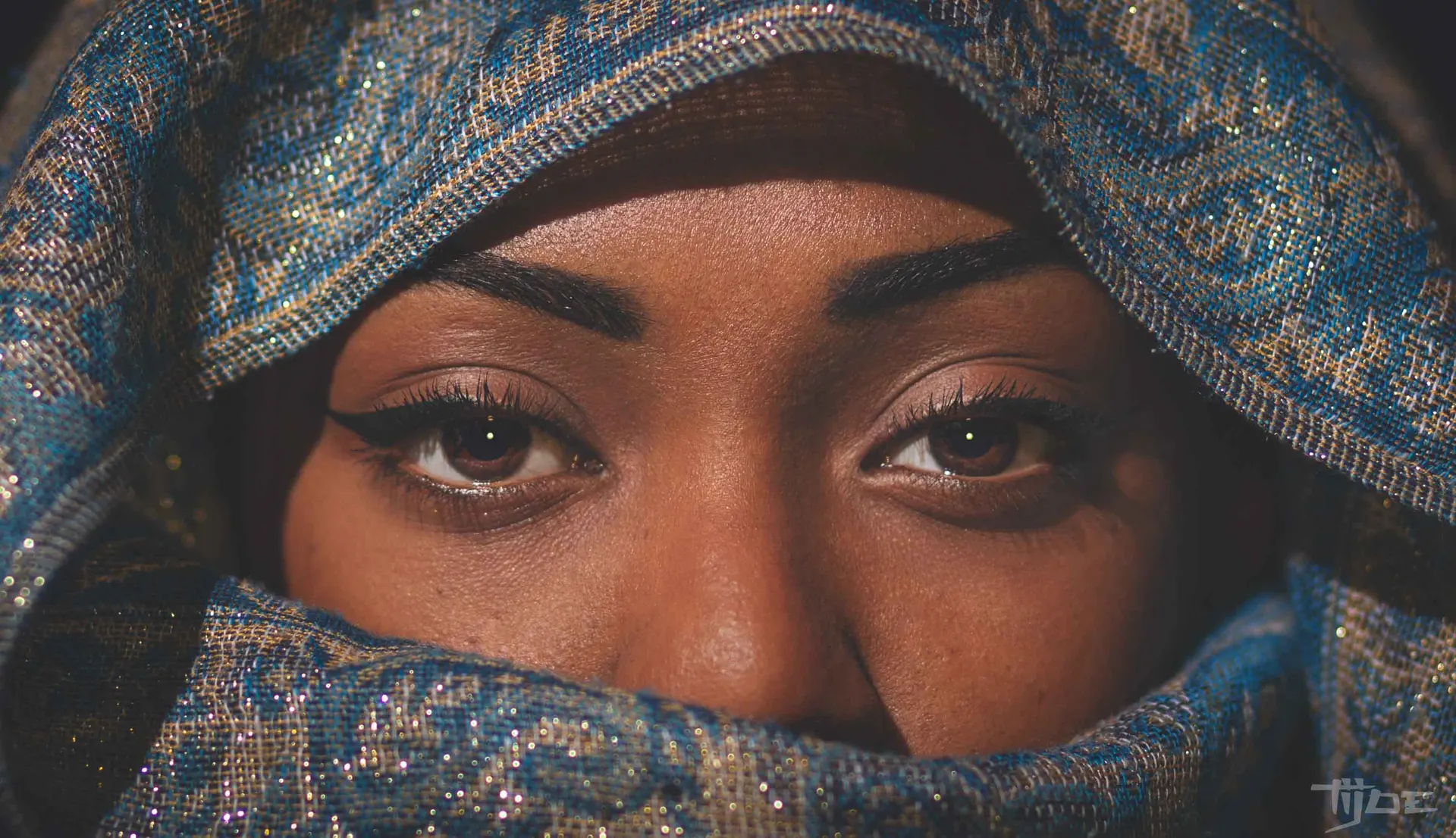 Gros plan sur les yeux d’une femme portant un foulard bleu orné, capturé par Tijoe, photographe et concepteur de site web à Mulhouse