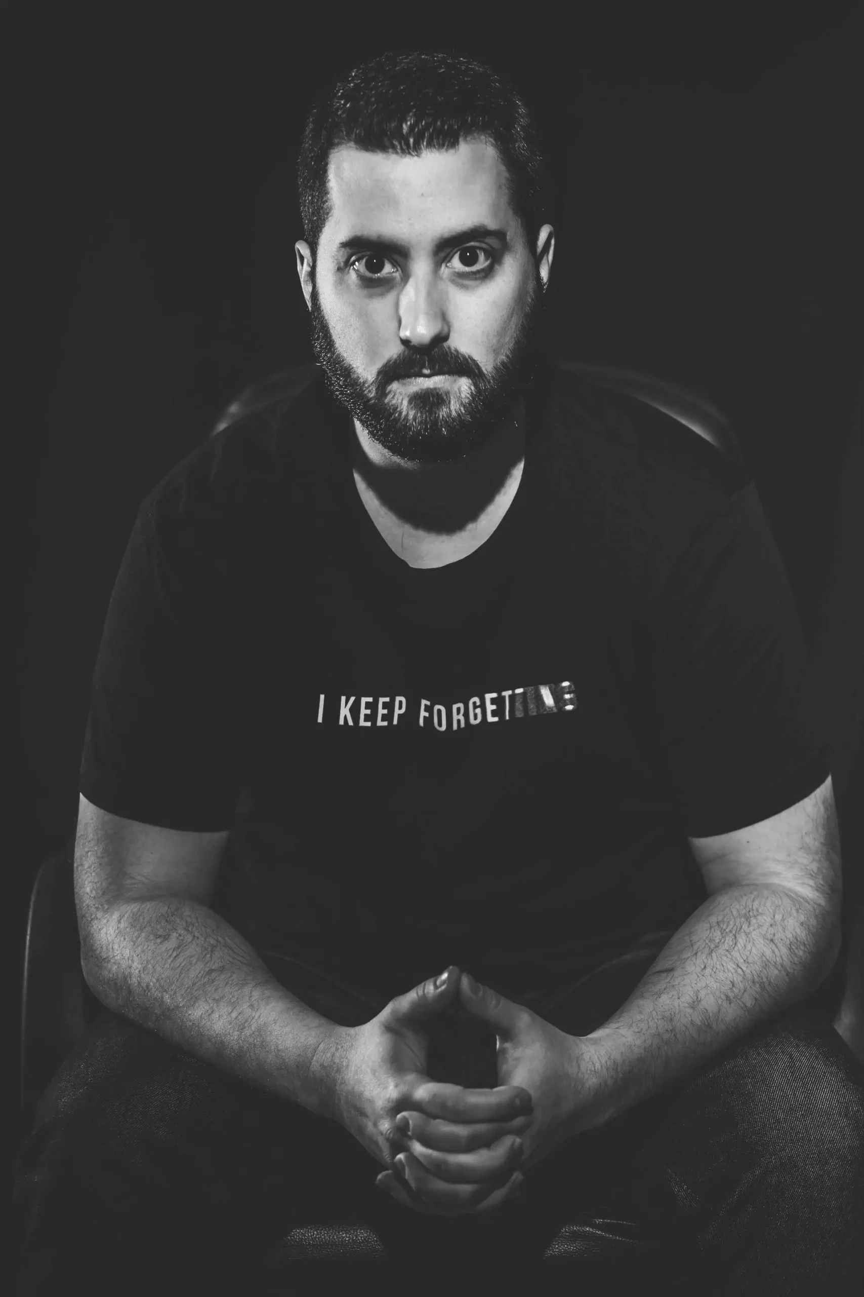 Homme assis face à l’objectif en noir et blanc, portrait studio réalisé par Tijoe, photographe et concepteur web à Mulhouse